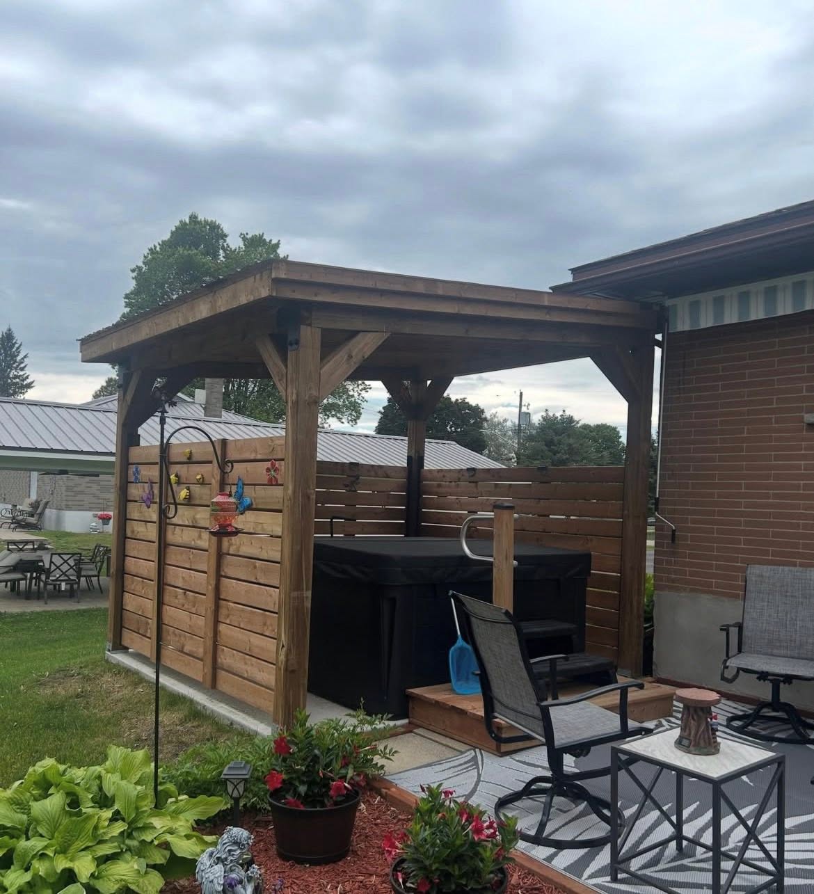 Timber roof structure and wood privacy screens beside a patio.