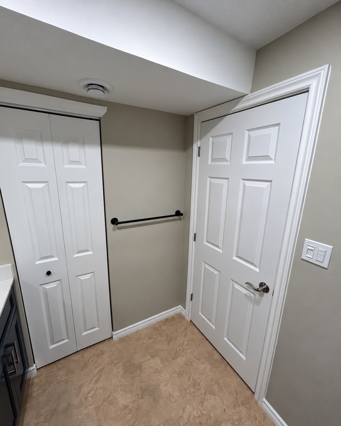 Bathroom doorway, tiled floor and wall-mounted grab bar.