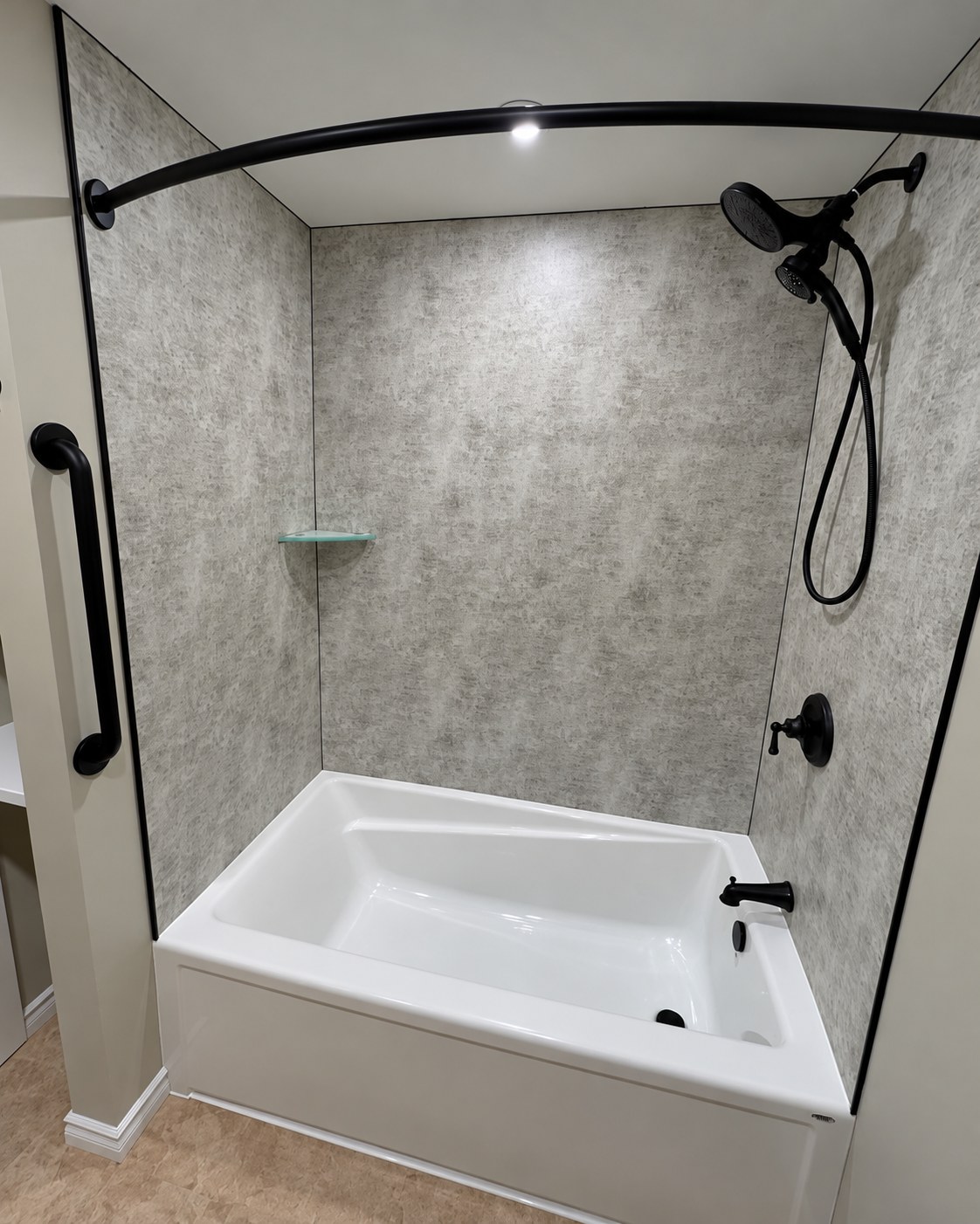 Bathtub with a patterned surround and black shower fixtures.