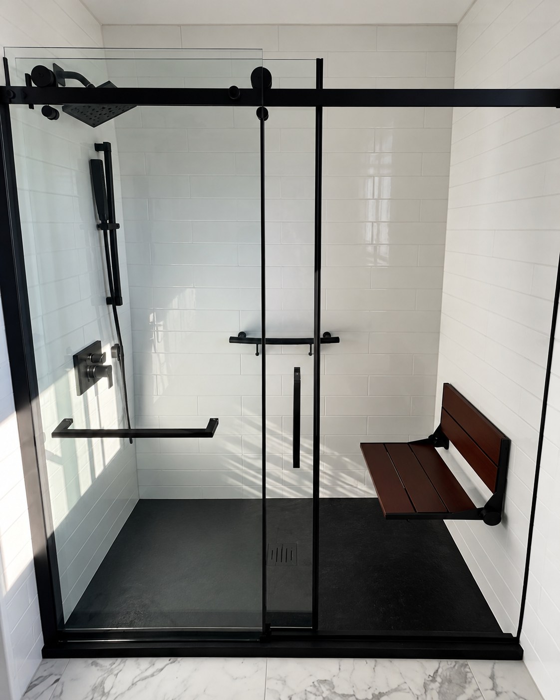 Glass shower enclosure with black fixtures and a wall-mounted bench.