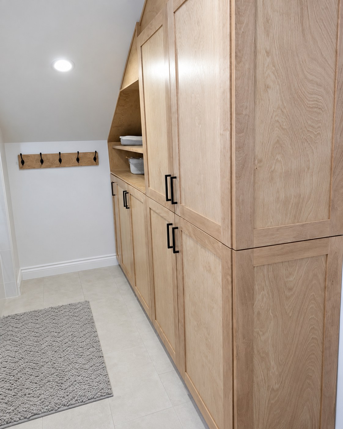 Full-height wood bathroom storage with drawers and open shelving.