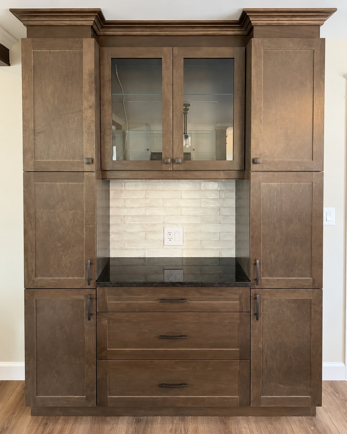 Wood display cabinet with glass doors, drawers and a tiled inset.