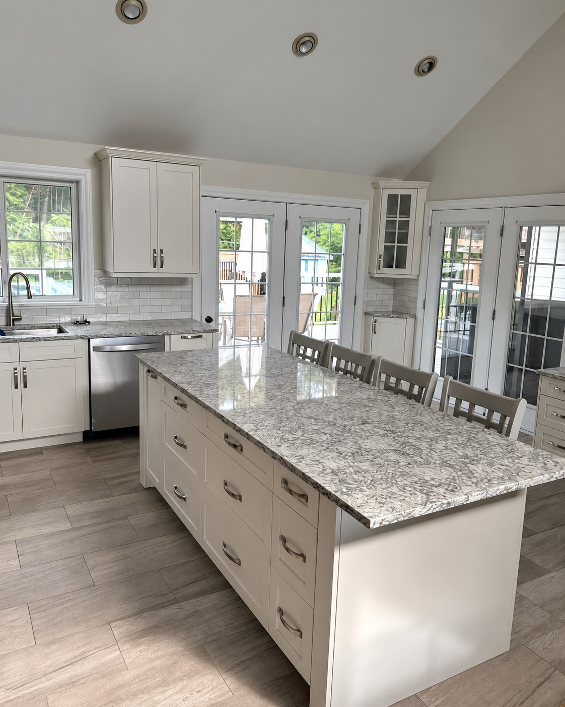 Kitchen island with drawers, seating and pendant lighting.