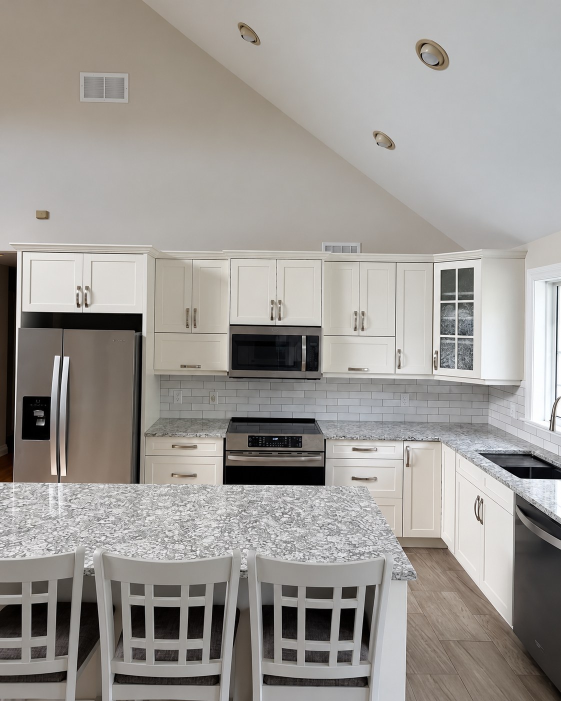 White cabinetry surrounding stainless-steel appliances.