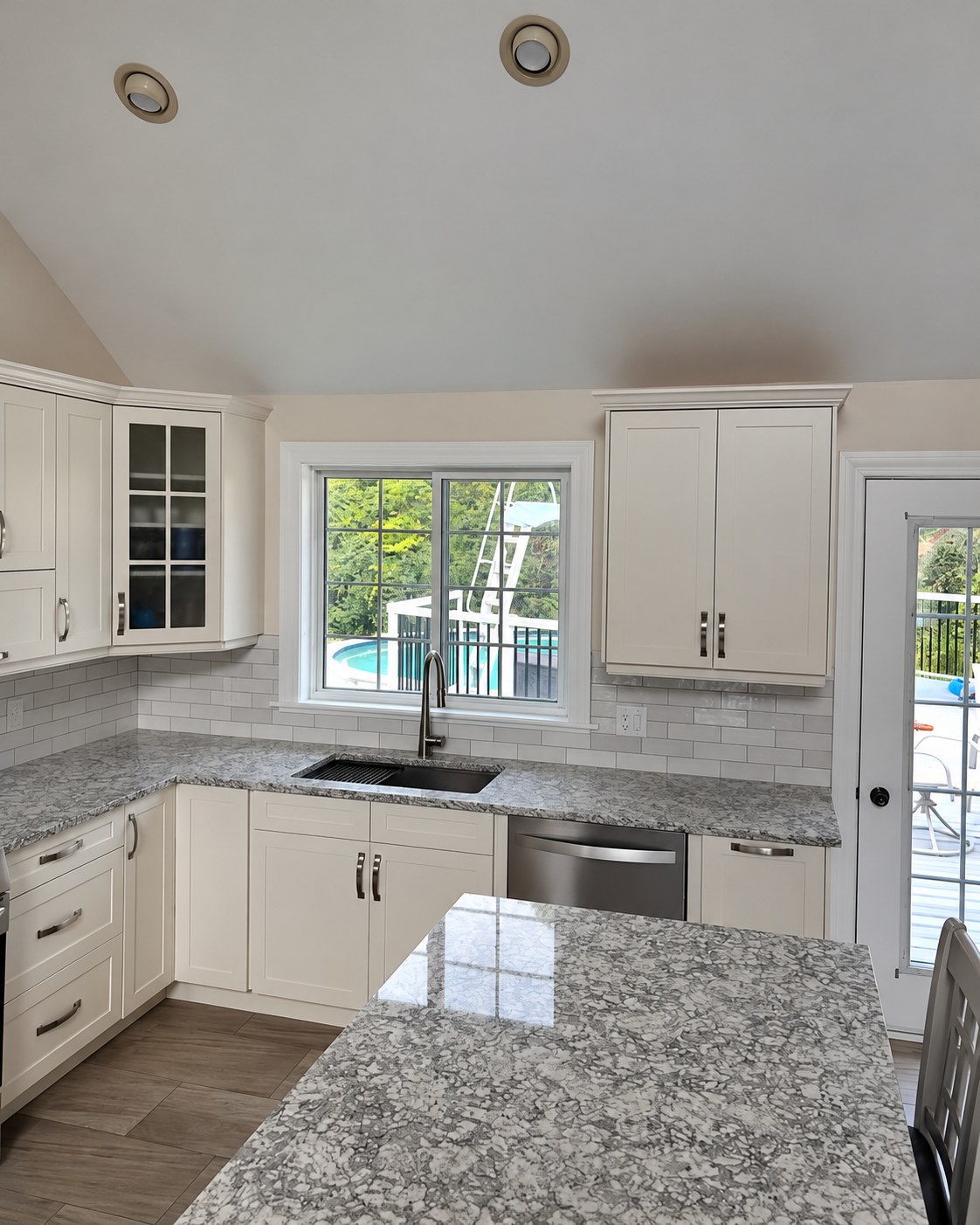 Corner kitchen counters and a sink below the window.