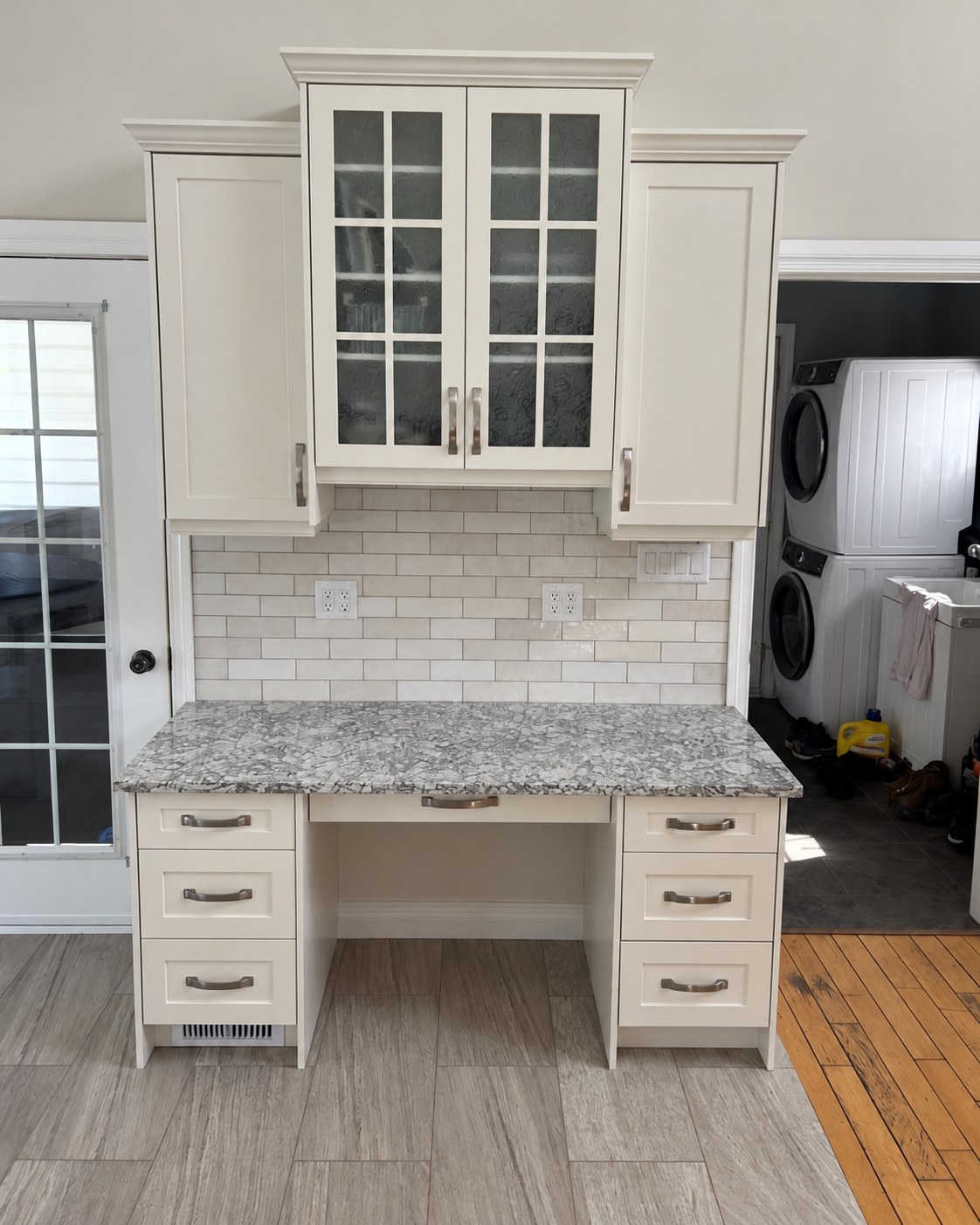 Glass-front upper cabinets above a counter and drawers.