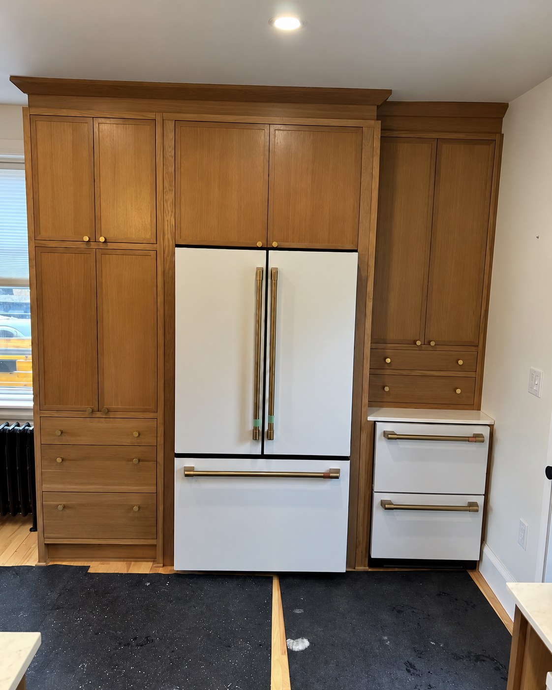 Wood cabinetry with tall storage beside the refrigerator.