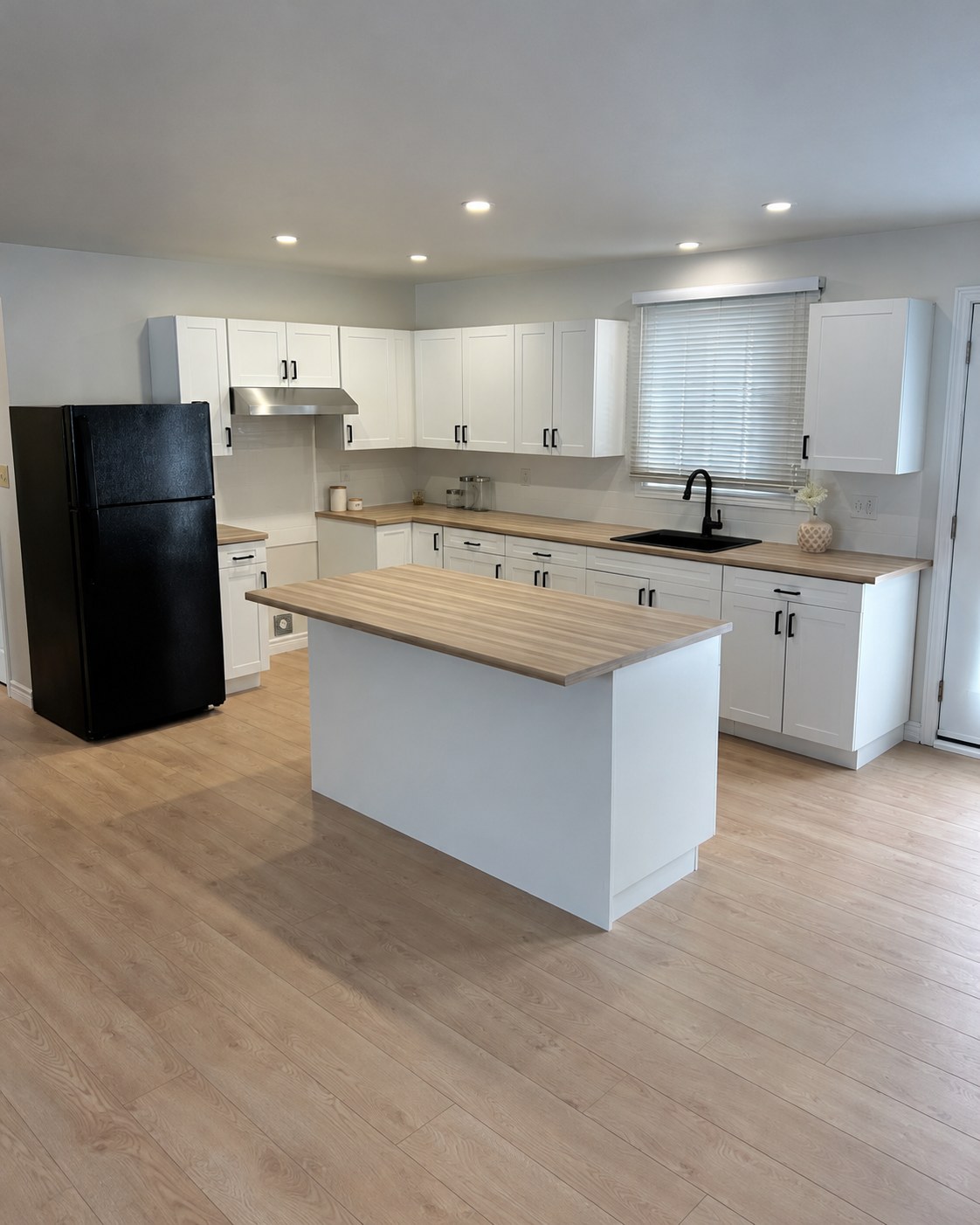 White cabinets, wood counters and a central island.