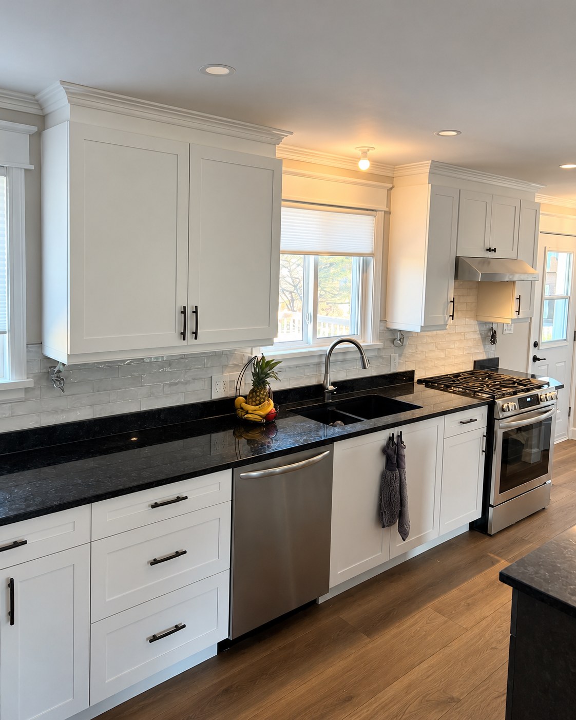 White cabinetry and dark counters along the kitchen wall.